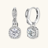 Sterling silver twisted hoop earrings with round moissanite stones in halo settings against neutral background.