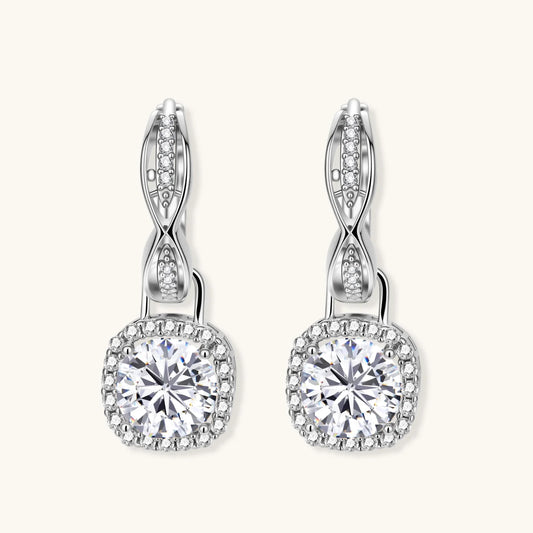 Sterling silver twisted hoop earrings with round moissanite stones in halo settings against neutral background.