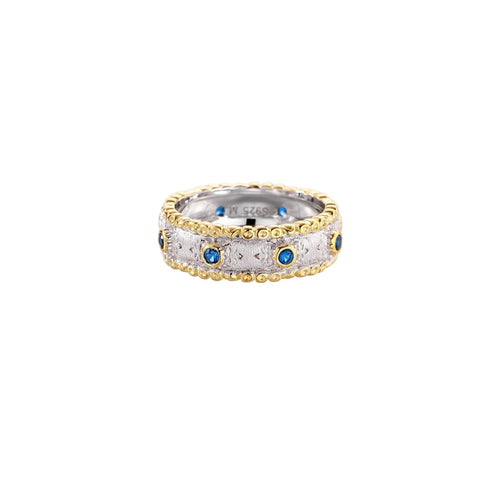 Two-tone ring with brushed silver center, gold beaded edges, and blue zirconia stones on white background.