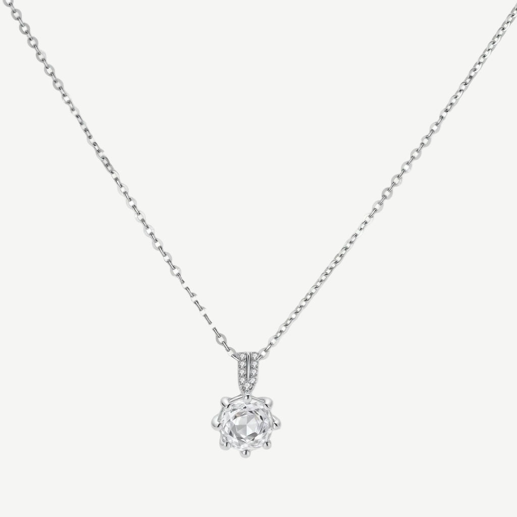 Platinum-plated sterling silver necklace with round clear crystal pendant and decorative bail on neutral background.