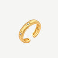 Gold open-band cuff ring with brushed matte finish, engraved 8-point star motifs, and round CZ stones on white background.